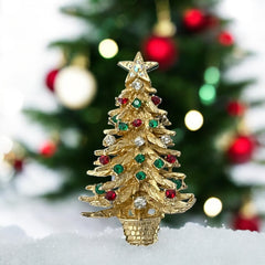 Vintage 1980s gold tone Christmas tree brooch with red, green, and clear rhinestones, featuring a star topper and woven basket base; shown from multiple angles to highlight dimensional detail, condition, and clasp.