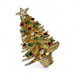 Vintage 1980s gold tone Christmas tree brooch with red, green, and clear rhinestones, featuring a star topper and woven basket base; shown from multiple angles to highlight dimensional detail, condition, and clasp.