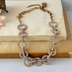 Vintage gold tone necklace with interlocking clear rhinestone circle links and lobster clasp.