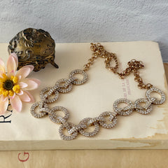 Vintage gold tone necklace with interlocking clear rhinestone circle links and lobster clasp.
