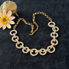 Vintage gold tone necklace with interlocking clear rhinestone circle links and lobster clasp.