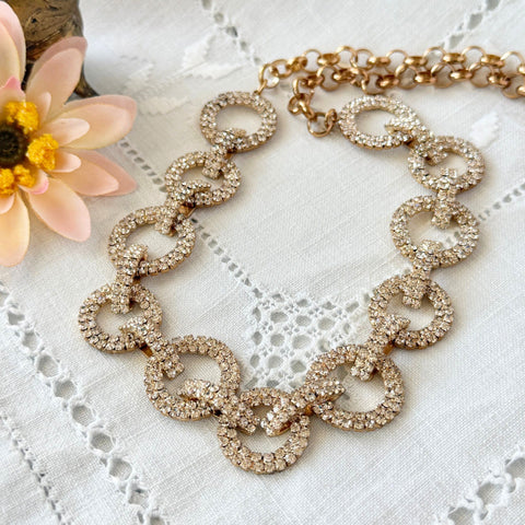 Vintage gold tone necklace with interlocking clear rhinestone circle links and lobster clasp.