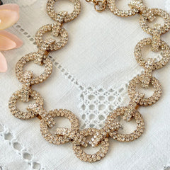 Vintage gold tone necklace with interlocking clear rhinestone circle links and lobster clasp.