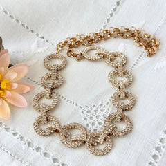Vintage gold tone necklace with interlocking clear rhinestone circle links and lobster clasp.