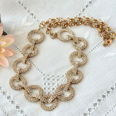 Vintage gold tone necklace with interlocking clear rhinestone circle links and lobster clasp.
