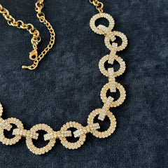 Vintage gold tone necklace with interlocking clear rhinestone circle links and lobster clasp.