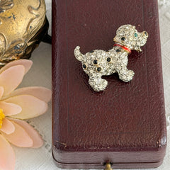 Vintage gold‑tone dog brooch with clear and black pavé rhinestones and a red enamel collar.