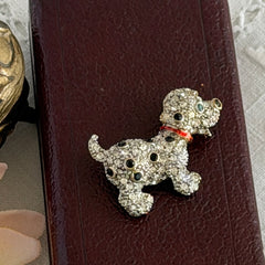 Vintage gold‑tone dog brooch with clear and black pavé rhinestones and a red enamel collar.