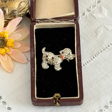Vintage gold‑tone dog brooch with clear and black pavé rhinestones and a red enamel collar.