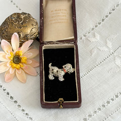 Vintage gold‑tone dog brooch with clear and black pavé rhinestones and a red enamel collar.