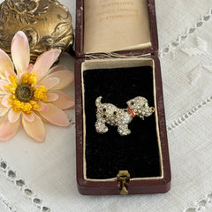 Vintage gold‑tone dog brooch with clear and black pavé rhinestones and a red enamel collar.