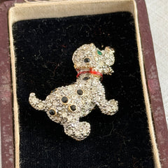 Vintage gold‑tone dog brooch with clear and black pavé rhinestones and a red enamel collar.