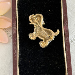 Vintage gold‑tone dog brooch with clear and black pavé rhinestones and a red enamel collar.