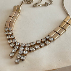 Vintage gold‑tone necklace with rectangular links and a clear rhinestone fringe.