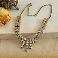 Vintage gold‑tone necklace with rectangular links and a clear rhinestone fringe.