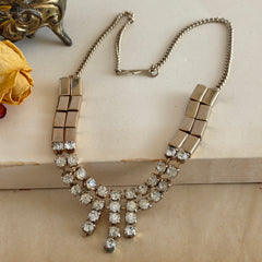 Vintage gold‑tone necklace with rectangular links and a clear rhinestone fringe.