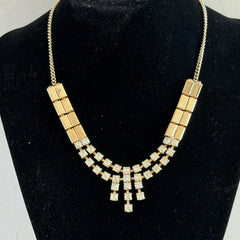 Vintage gold‑tone necklace with rectangular links and a clear rhinestone fringe.
