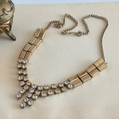 Vintage gold‑tone necklace with rectangular links and a clear rhinestone fringe.