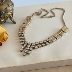 Vintage gold‑tone necklace with rectangular links and a clear rhinestone fringe.