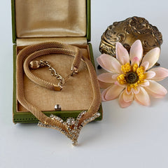 Vintage 1960s gold tone mesh necklace with clear rhinestone centerpiece, shown from multiple angles on display.