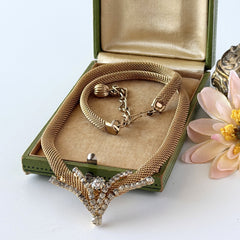 Vintage 1960s gold tone mesh necklace with clear rhinestone centerpiece, shown from multiple angles on display.