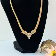 Vintage 1960s gold tone mesh necklace with clear rhinestone centerpiece, shown from multiple angles on display.