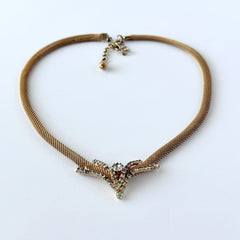 Vintage 1960s gold tone mesh necklace with clear rhinestone centerpiece, shown from multiple angles on display.
