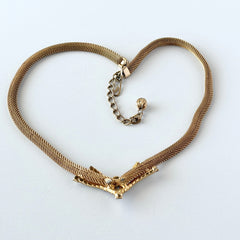 Vintage 1960s gold tone mesh necklace with clear rhinestone centerpiece, shown from multiple angles on display.