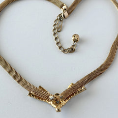 Vintage 1960s gold tone mesh necklace with clear rhinestone centerpiece, shown from multiple angles on display.