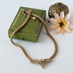 Vintage 1960s gold tone mesh necklace with clear rhinestone centerpiece, shown from multiple angles on display.