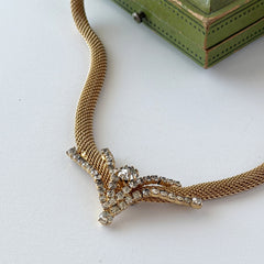 Vintage 1960s gold tone mesh necklace with clear rhinestone centerpiece, shown from multiple angles on display.