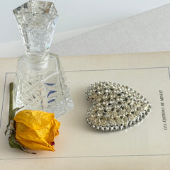 Vintage silver‑tone heart brooch with clear rhinestones in a pavé heart design.