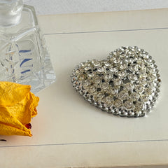 Vintage silver‑tone heart brooch with clear rhinestones in a pavé heart design.
