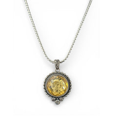 Vintage Cookie Lee necklace featuring a faceted yellow Lucite pendant with a rose intaglio in an ornate silver tone setting, hanging from a thick serpentine chain.