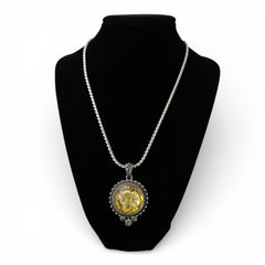 Vintage Cookie Lee necklace featuring a faceted yellow Lucite pendant with a rose intaglio in an ornate silver tone setting, hanging from a thick serpentine chain.