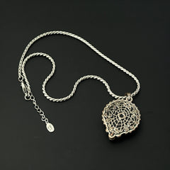 Vintage Cookie Lee necklace featuring a faceted yellow Lucite pendant with a rose intaglio in an ornate silver tone setting, hanging from a thick serpentine chain.