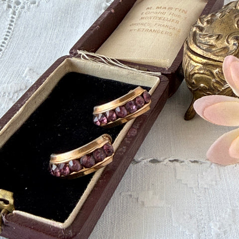 Vintage Coro gold‑tone half‑hoop earrings with amethyst rhinestones and screw‑back closures, shown from multiple angles.