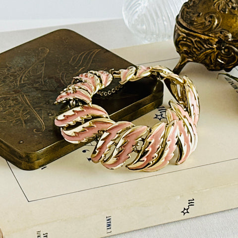 Vintage gold‑tone Coro bracelet with peach enamel feather links and safety chain, 1950s design.