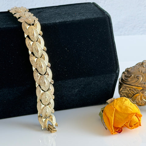 Vintage gold‑tone Coro link bracelet with textured interlocking links shown in various angles and backgrounds.