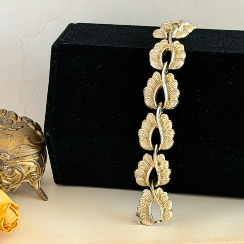 Vintage 1960s Coro light gold tone bracelet with textured leaf links, signed clasp, and safety chain.