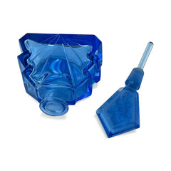 Vintage Czech Art Deco sapphire blue fan‑shaped perfume bottle with geometric stopper and frosted intaglio floral dauber, shown in styled settings that highlight its faceted design, vibrant color, and collectible craftsmanship.