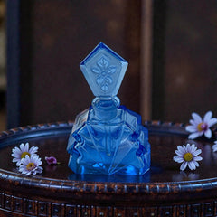 Vintage Czech Art Deco sapphire blue fan‑shaped perfume bottle with geometric stopper and frosted intaglio floral dauber, shown in styled settings that highlight its faceted design, vibrant color, and collectible craftsmanship.