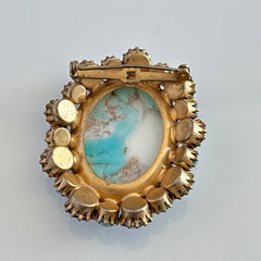 Vintage Czech statement brooch featuring a large faux turquoise Hubbell glass oval cabochon surrounded by alternating capri blue and light sapphire rhinestones in a gold‑tone prong‑set setting, shown from various angles.