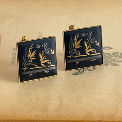 Vintage Amita Japan damascene square cufflinks with gold and silver bamboo motif on black enamel, signed on the back, displayed on a neutral surface.