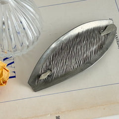 Vintage Danish S.I.D. pewter hair barrette with textured diagonal surface and signed back, elongated oval shape, 1970s–80s Scandinavian design.