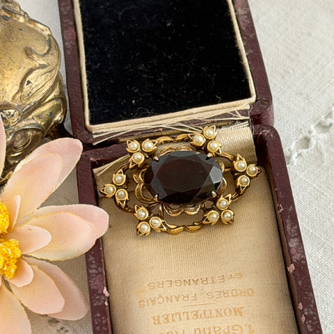 Vintage gold‑tone Victorian Revival brooch with red faceted glass cabochon and faux pearls.