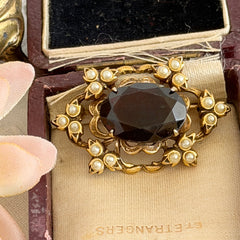Vintage gold‑tone Victorian Revival brooch with red faceted glass cabochon and faux pearls.