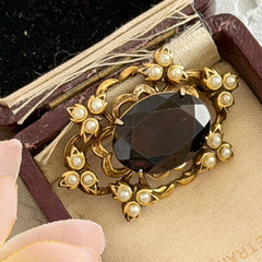 Vintage gold‑tone Victorian Revival brooch with red faceted glass cabochon and faux pearls.