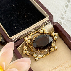 Vintage gold‑tone Victorian Revival brooch with red faceted glass cabochon and faux pearls.