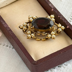 Vintage gold‑tone Victorian Revival brooch with red faceted glass cabochon and faux pearls.